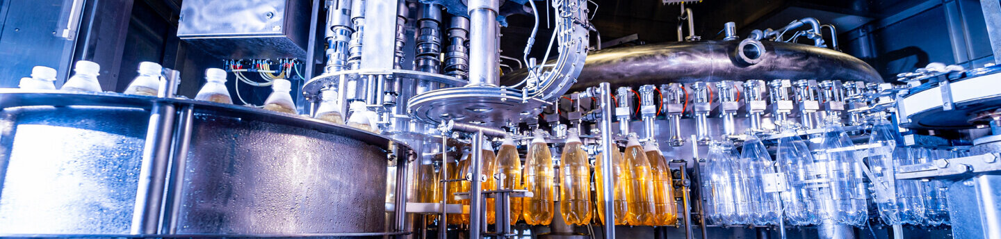 Automatic filling machine, pours beverage into PET plastic bottles.