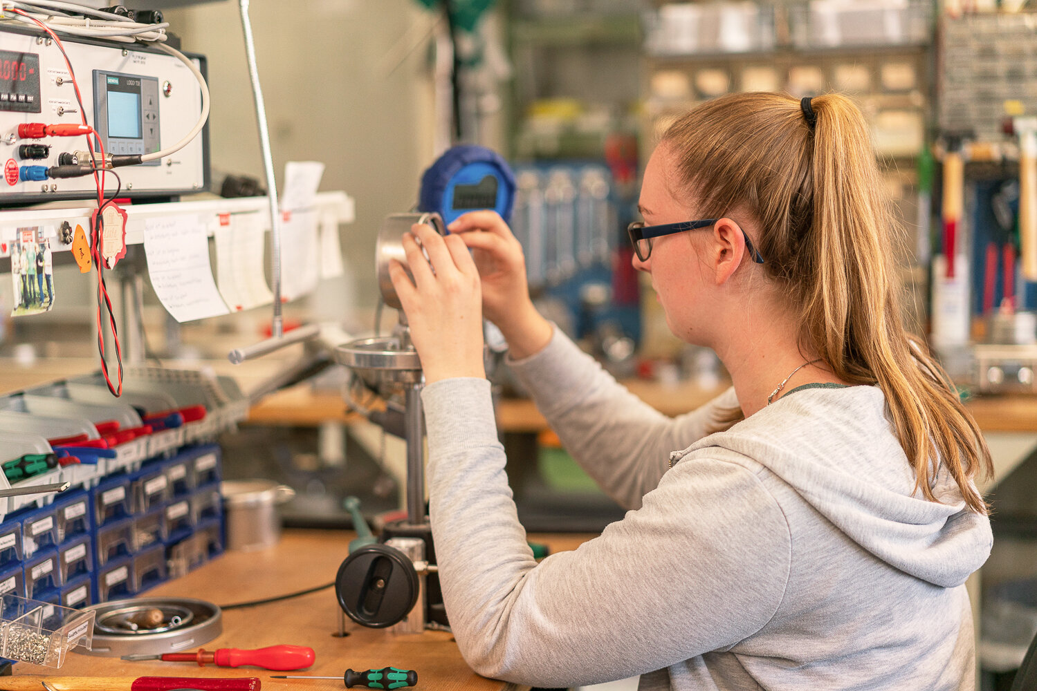 Eine Mitarbeiterin der Produktion beim kalibrieren eines Manometers.