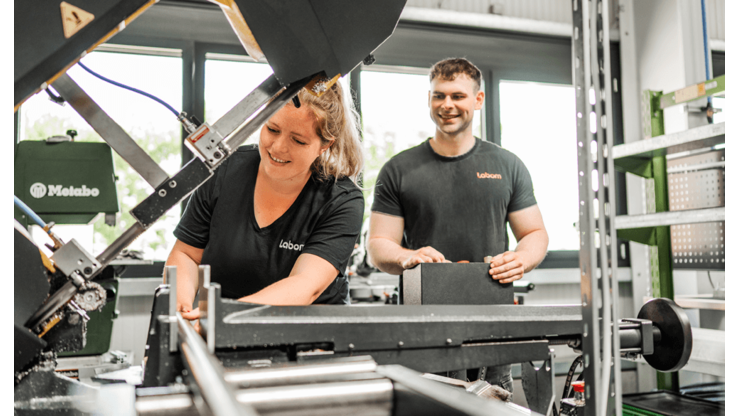 Zwei Mitarbeiter an einer Metallbandsäge
